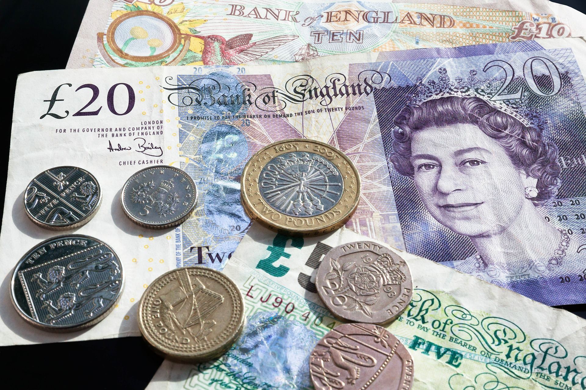 coins lying on top of pound notes
